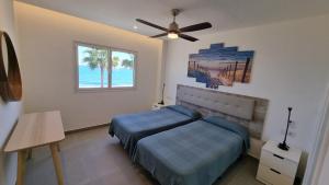a bedroom with a bed and a ceiling fan at Costa Luz Beach Apartments in Puerto del Carmen +13 photos