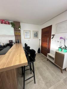 a kitchen with a wooden table and black chairs at Casa família local tranquilo in Garopaba