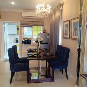 a dining room with a table and blue chairs at Thai Family Home in Ban Khlong Thewa