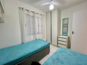 ウバトゥバにあるUbatuba UBA-HOME Apto 116の青いベッドと窓のある寝室 +14枚の写真