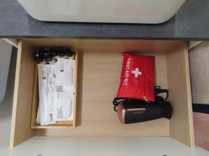 a box with a red bag and a bottle of wine at Chambre deux personnes avec salle de bain privative in Bondy