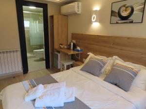 a bedroom with a large white bed and a bathroom at Chambre deux personnes avec salle de bain privative in Bondy