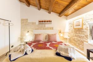 Un dormitorio con una cama grande en una pared de piedra. en Villa Antica Aia con piscina, en Scicli 28 fotos más