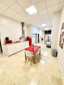 a kitchen with a red table and chairs in a room at Apartamentos Bobal Requena in Requena +28 photos