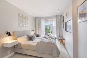 une chambre avec un grand lit et une fenêtre dans l'établissement Klif Apartamenty Polanki Park, à Kołobrzeg 45 autres photos