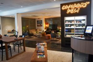 a restaurant with a bar with a drink refrigerator at Comfort Hotel Norrköping in Norrköping