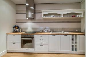 a kitchen with white cabinets and a sink at udanypobyt Apartamenty Pastelowe in Zakopane