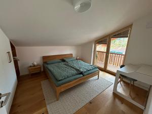 a bedroom with a bed and a balcony at Apartment Virgo7 - stylisch, neuerbaut und topausgestattet in Fischbachau