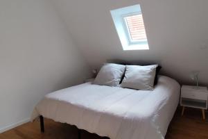 a bedroom with a bed with two pillows and a window at Belle petite maison de 70m2 in Neuwiller-lès-Saverne
