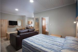 une chambre avec un lit, un canapé et une télévision dans l'établissement Gariep, A Forever Resort, à Gariepdam 53 autres photos