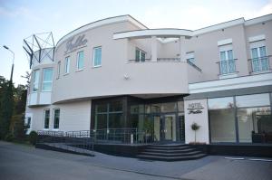 a large white building with stairs in front of it at Hotel Falko in Rumia