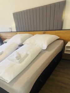 a pair of beds with white pillows on them at FeWo 13 - Appartement im Rottalblick - Elegant und ruhig wohnen, Tiere willkommen, Bademantelgang zur Therme, TV, Boxspringbett, Balkon inkl Garage u Kurtaxe in Bad Griesbach +20 photos