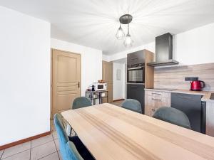 a kitchen with a table and chairs in a room at Chez Marianne Résidence Piscine Sauna in Levernois