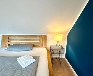 a bedroom with a bed and a table with a lamp at Aparthotel Pumpengasse in Wolfsburg