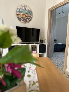 a living room with a clock on the wall and a table at La Dimora di Porta Palermo -Centro Storico-Sciacca in Sciacca