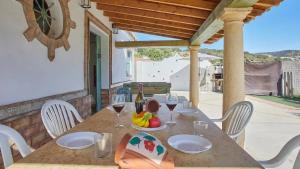 a table with a bowl of fruit and wine glasses at Luxurious Villa in Prado del Rey with Pool in Prado del Rey