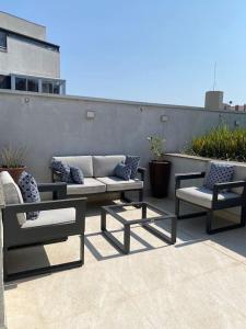 a patio with two chairs and a couch at Apartamento Espaçoso in Curitiba