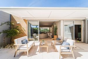 a patio with white chairs and a table at Viana Vista Villa in Viana do Castelo