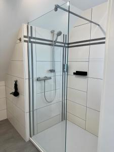 a shower with a glass door in a bathroom at MEINpartments - Full service living in Wolfsburg