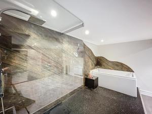 a bathroom with a large shower with a stone wall at Les pièces du puzzle in Dunkerque