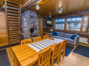ein Esszimmer mit einem Tisch und einem Steinkamin in der Unterkunft Holiday Home Kuusi-ruka 6 by Interhome in Rukatunturi 