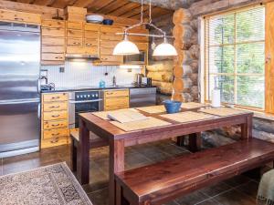 eine Küche mit Holztisch und Kühlschrank in der Unterkunft Holiday Home Villa olivia by Interhome in Rukatunturi 