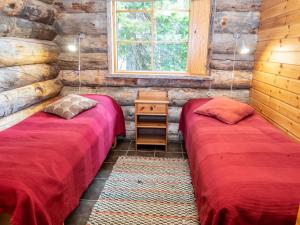 zwei Betten in einem Zimmer mit Holzwänden in der Unterkunft Holiday Home Villa olivia by Interhome in Rukatunturi  + 13 Fotos