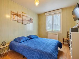QuinévilleにあるHoliday Home Les pieds dans l'eau by Interhomeのベッドルーム(青いベッド1台、テレビ付)
