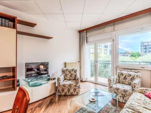 a living room with two chairs and a tv at Apartment SunnyLake by Interhome in Riva del Garda