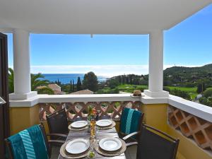 a table on a balcony with a view of the ocean at Apartment Village Cap Estérel - Le Village-80 by Interhome in Agay - Saint Raphael