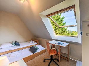a room with two beds and a desk and a window at Holiday Home Le Prado-2 by Interhome in Saint-Philibert