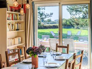 a table in a room with a large window at Holiday Home Le Prado-1 by Interhome in Saint-Philibert +20 photos