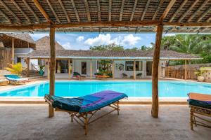 una villa con piscina e una casa di The Afters Boutique Hotel Diani a Diani Beach