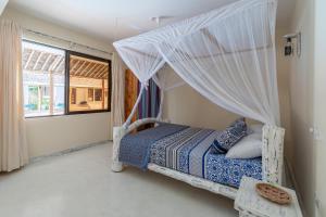 una camera da letto con un letto con zanzariera di The Afters Boutique Hotel Diani a Diani Beach