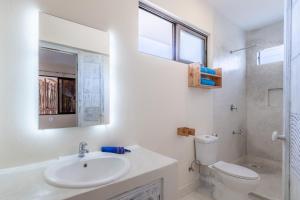 un bagno bianco con lavandino e WC di The Afters Boutique Hotel Diani a Diani Beach