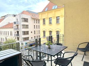 布达佩斯Spacious 3-bedroom with Balcony & Free Parking的带桌椅的阳台和建筑物