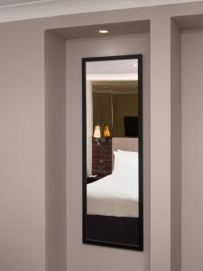 a mirror in a hotel room with a bed at Strand Palace in London
