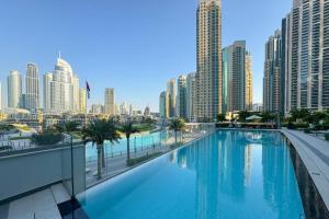 a large swimming pool in a city with tall buildings at Elegant Retreat with Stunning Burj Khalifa Views in Dubai