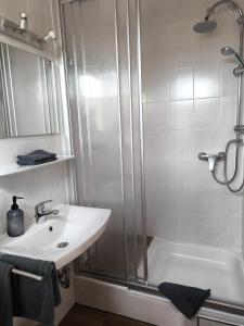 a white bathroom with a shower and a sink at Ferienwohnung Fleur in Bad Kohlgrub +6 photos