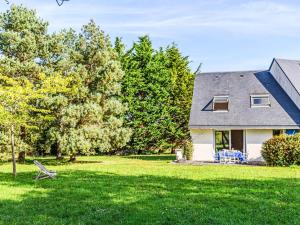 a house with a yard with green grass and trees at Holiday Home Le Prado-3 by Interhome in Saint-Philibert