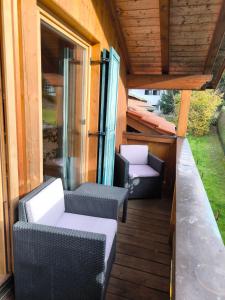 a balcony with chairs and tables on a house at Ferienwohnung Fleur in Bad Kohlgrub