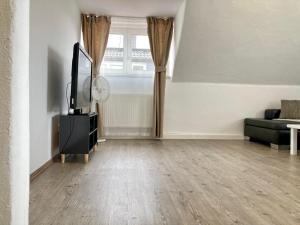 an empty living room with a tv and a couch at Helle Ferienwohnung in Lichtenfels Schney in Lichtenfels