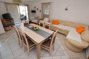 salon ze stołem i kanapą w obiekcie Apartment Kety w Novalji
