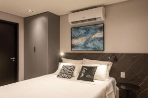a bedroom with a white bed with pillows on it at Way Tambaú #N4 - Studio triplo deluxe by Carpediem in Tambaú +32 photos