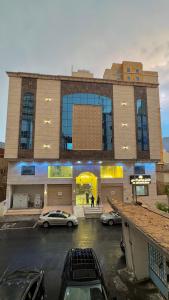 a building with cars parked in a parking lot at فندق جواهر الهدى in Makkah