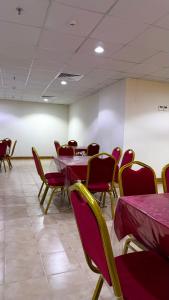 a room with tables and chairs with purple table cloths at فندق جواهر الهدى in Makkah
