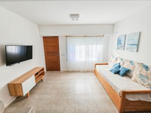 a living room with a couch and a flat screen tv at Dúplex Familiar Av 5 y Paseo 117 in Villa Gesell