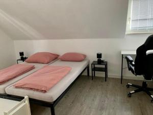 a bedroom with two beds and a desk and a chair at Helle Ferienwohnung in Lichtenfels Schney in Lichtenfels