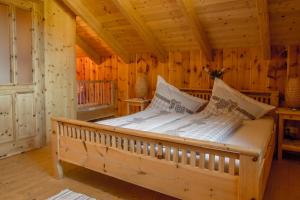 a bed in a wooden room in a cabin at Haus Paradies am See in Grundlsee