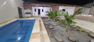 una piscina davanti a una casa con palme di Jalehe a Juazeiro do Norte